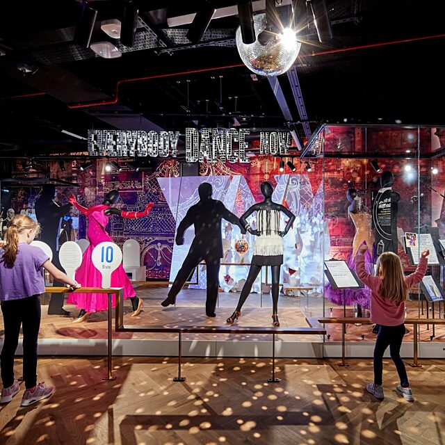 Dance gallery at Showtown.  Two girls dancing and playing with score paddles with dance costumes on models